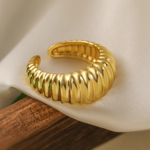 Golden heart geometric open ring with textured croissant pattern on silk backdrop