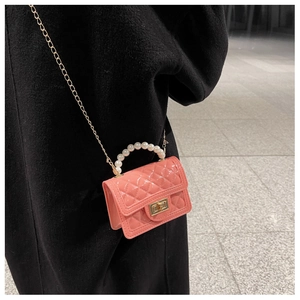 Close-up of bright pink jelly bag with pearl handle and golden chain strap for kids