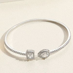 Macro shot of silver open cuff bracelet with pear and square cut cubic zirconia gems