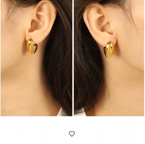 Auffällige goldene polierte dicke Creolen, am Modell in einer Seitenansicht gezeigt