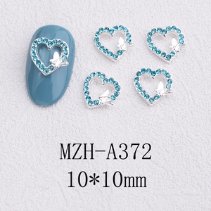 Macro shot of 10x10mm light blue rhinestone hollow heart nail art charm with a silver bow