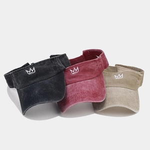 Detailed close-up of three vintage washed cotton sun visors with crown embroidery motifs