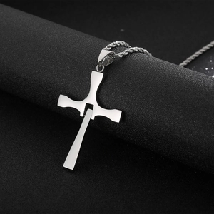 Macro view of silver stainless steel cross pendant with diamond-set twist chain details