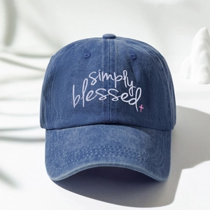Detail of simply blessed embroidery and pink cross on washed denim baseball cap