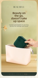 Compact dark green velvet jewelry case shown being tucked into a bag for portability