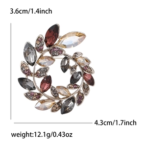 Elegant crystal olive wreath brooch with multi-colored stones on a white background