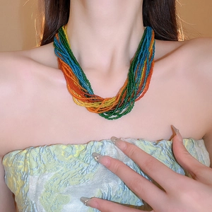 Dettaglio macro della collana bohémien a più strati con perline colorate su modella