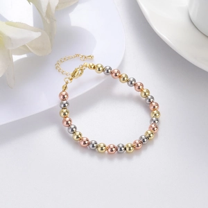 Detailed macro of tri-color metal beaded bracelet with adjustable lobster clasp and extension