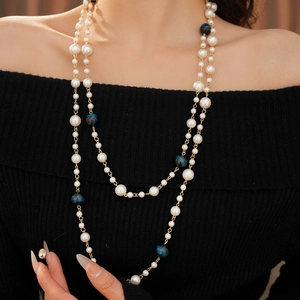 Close-up of double-layer beaded necklace with white pearls and blue tiger eye glass beads