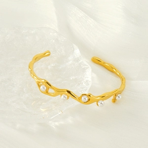 18K gold-plated irregular wave bangle with five white pearls on a silk background