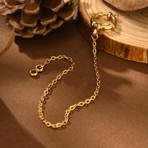 Close-up of golden stainless steel flat cross chain with round bubble clasp detail