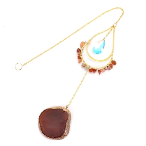 Detail of natural agate slice and sun catcher moon pendant with gold metal chains