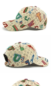 Detail van kleurrijk letterborduurwerk op beige jacquard baseballpet met metalen gesp