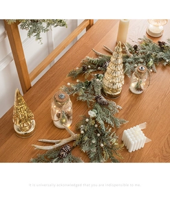 Dettaglio decorazione natalizia nordica con ghirlanda d'argento, alberi LED e candela