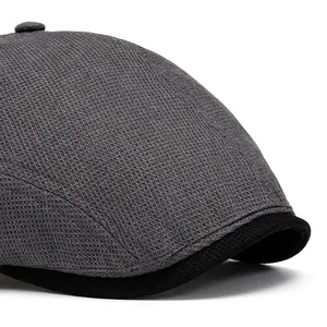 Side view of a grey mesh beret hat with black trim and a vintage flat cap silhouette