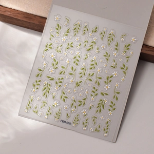 Macro detail of 5D floral nail stickers with embossed white daisies and green leaves