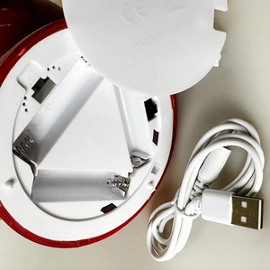 Detail of Santa snow globe battery compartment and USB charging cable for power supply