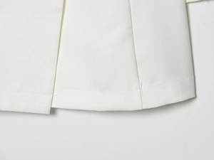 Close-up of clean stitching and high-quality hem detail on white office skirt suit