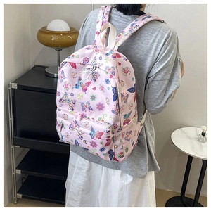 Vista posteriore di uno zaino rosa con stampe di farfalle e fiori in casa