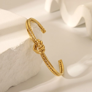 Eleganter goldener Knoten-Armreif aus poliertem Edelstahl mit minimalistischem Knotendesign