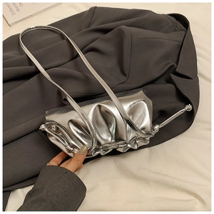 Close-up of a metallic silver pleated cloud bag featuring glossy PU leather texture