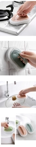 Detail of pink and green cleaning sponges with ergonomic handles used on kitchen surfaces