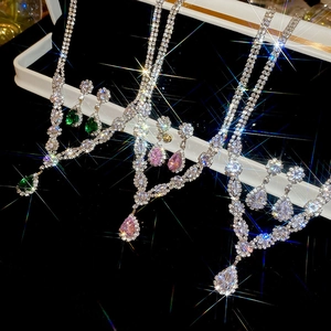 Detailed view of teardrop zircon necklace and earring sets in green, pink, and white