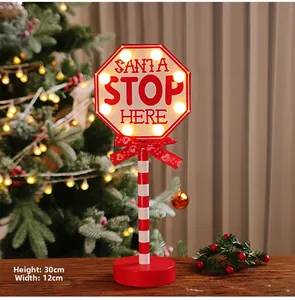 Close-up of LED Santa Stop Here road sign with red bow and striped wooden pole, 30cm high