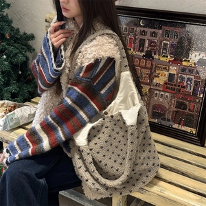 Detailed texture of plush lamb wool tote bag with navy blue polka dots in winter setting