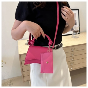 Détail du sac à main sablier rose avec poignée nouée et mini pochette assortie