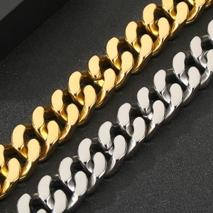 Close-up of gold and steel tone Cuban link bracelets showing polished titanium steel texture