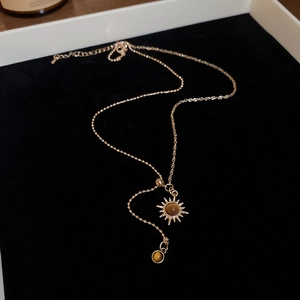 Vue détaillée d'un collier pendentif tournesol doré avec pierre œil de tigre vintage