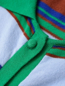 Macro shot of striped knit polo shirt detailing high-quality fabric and green fabric button