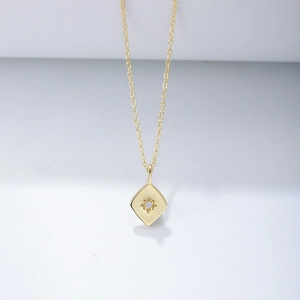 Detailaufnahme des goldenen Rautenanhängers mit Sternmotiv und kleinem Diamantbesatz