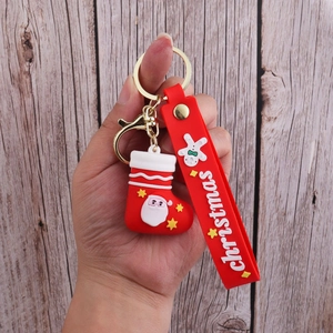 Close-up of red Christmas stocking keychain with silicone strap held in hand