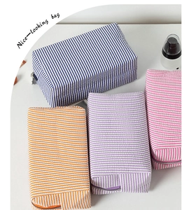Makroaufnahme der gestreiften Seersucker-Kulturtaschen in Blau Orange Violett und Rosa