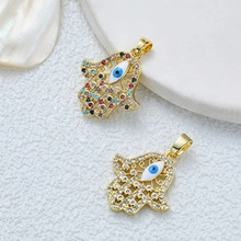Detailed close-up of 18K gold Hamsa pendants with colorful stones and evil eye motifs