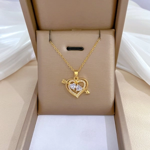 Elegant gold titanium heart necklace with shimmering crystals in a beige gift box