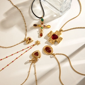 Flat lay of vintage gold stainless steel necklaces with red agate and pearl pendants