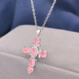 Close-up of silver cross necklace with pink pear-shaped cubic zirconia crystals