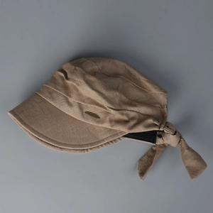 Close-up of khaki cotton linen sun hat with pleated brim and gold label detail
