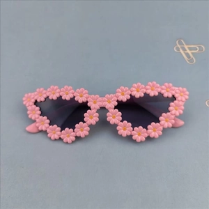 Detail of pink cat-eye sunglasses with 3D daisy flower decorations for girls