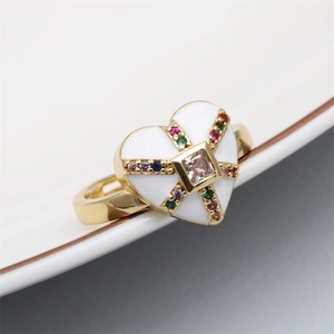 Macro view of gold heart ring with white enamel and colorful pavé cubic zirconia