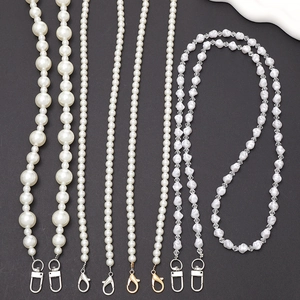 Assorted DIY pearl phone cross-body straps with silver and gold metal clasps on gray background