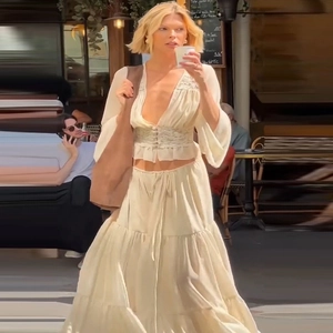 Detail of a beige lace chiffon top and tiered maxi skirt with a brown tote bag