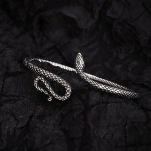 Retro silver snake bracelet with detailed scale texture on a dark textured background