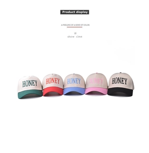 Detail of five cotton baseball caps with HONEY embroidery in multiple color variants