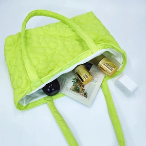 Detail view of fluorescent quilted tote bag with floral patterns and large interior capacity