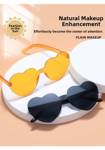 Detail of heart-shaped rimless sunglasses in transparent orange and classic black colors