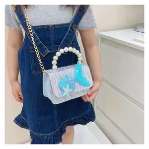 Detail of girl's tweed mini bag with pearl handle and sequin mermaid tail decorations